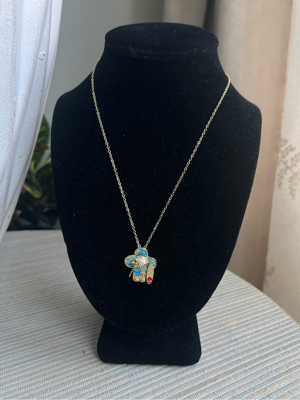 blue surfer floral gold pendant with pavé accents and detailed surfboard